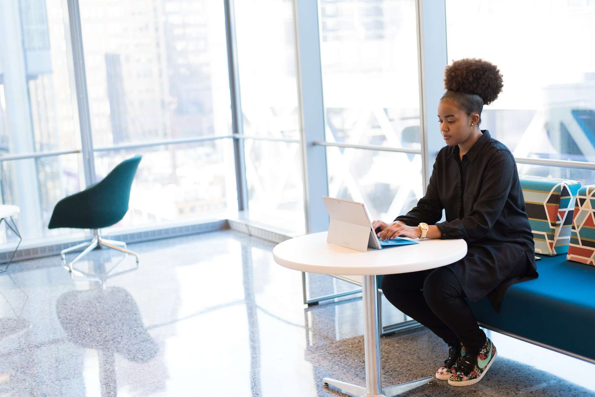 woman sitting on sofa while using surface
