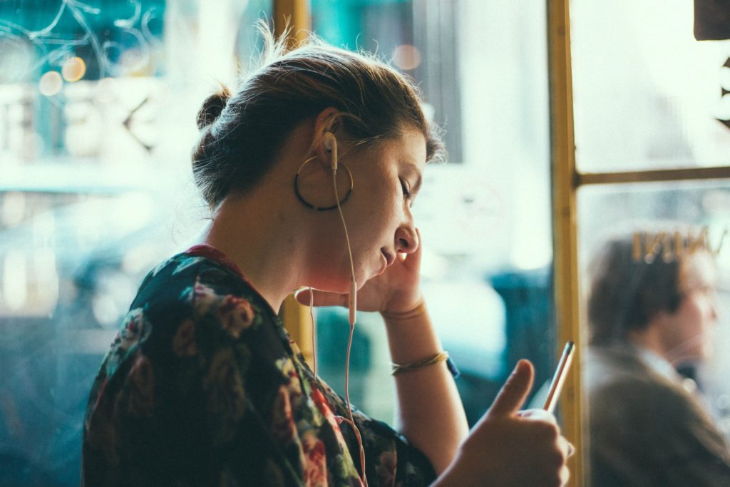 woman using white earphones
